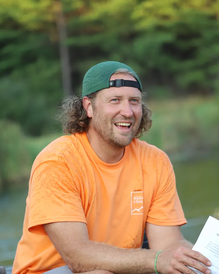 Caleb McClain laughing on a bench by the water